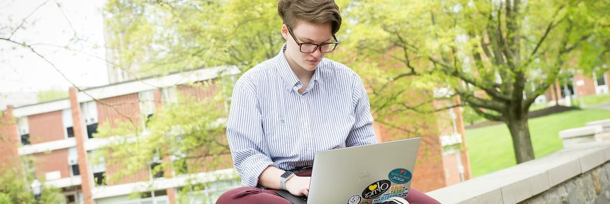 A student work on a laptop studying on the wall of the Rossin Campus Center patio during the Creosote Affects photo shoot May 1, 2019 at Washington & Jefferson College.